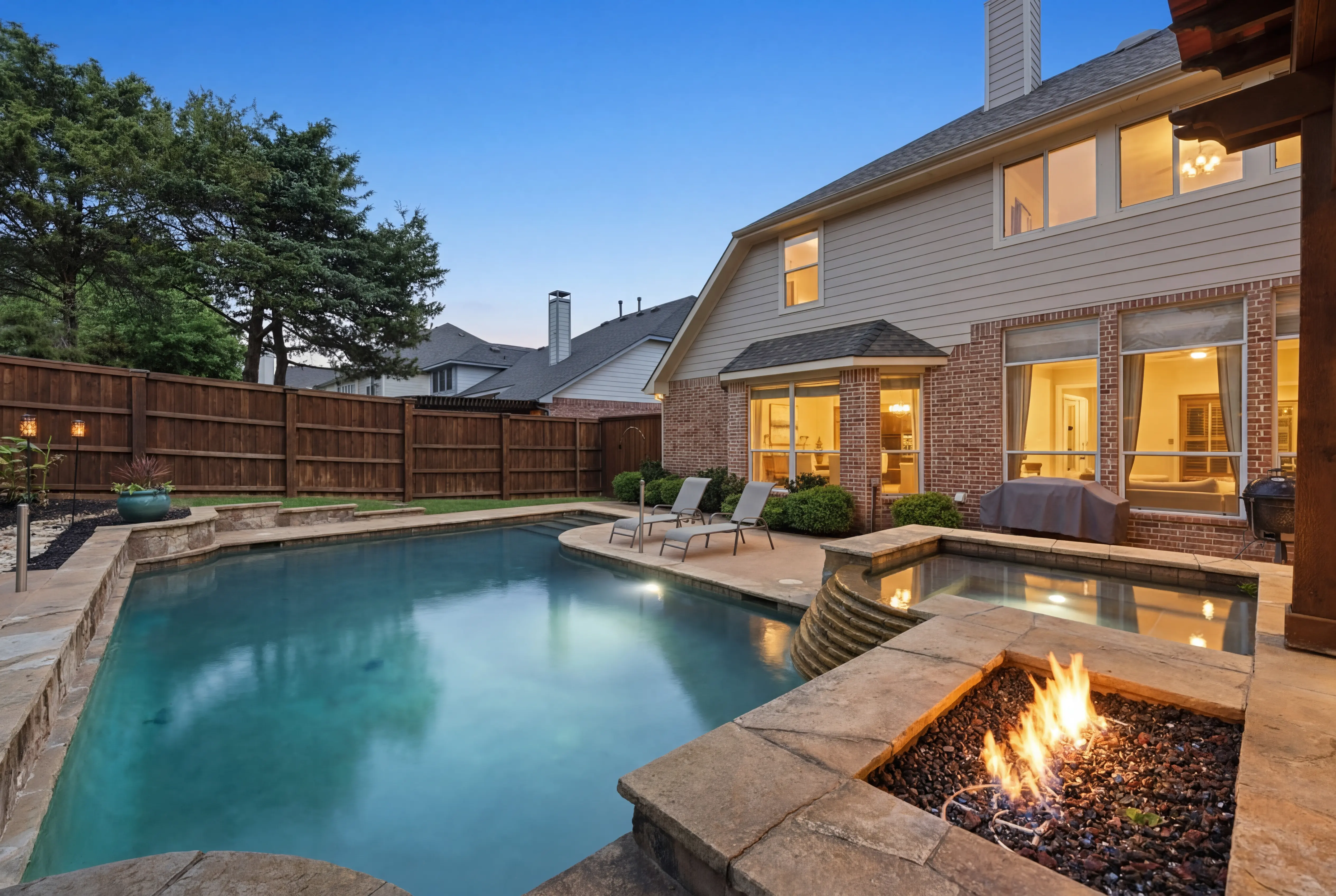 Pool with fire pit at dusk
